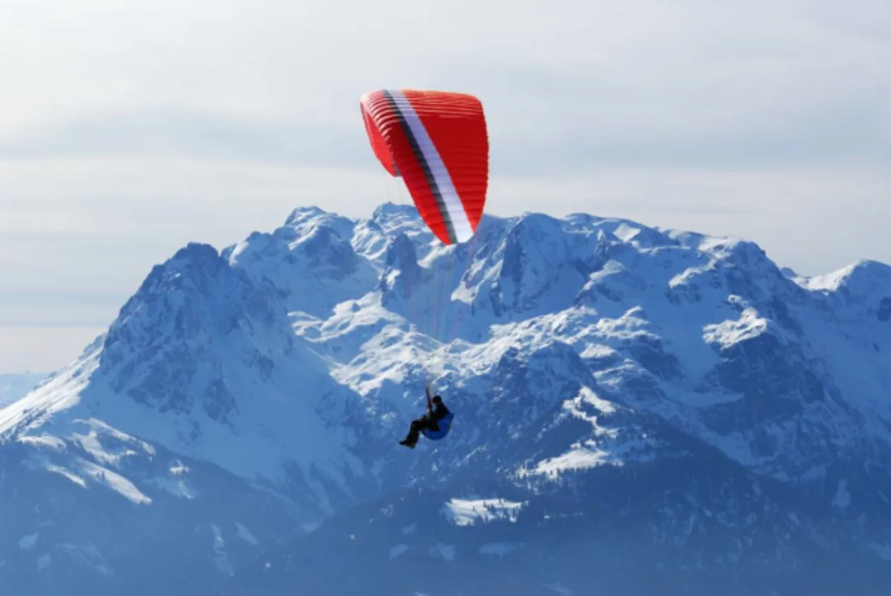 A paraglider soars over the Swiss Alps.